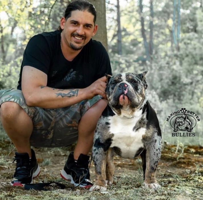 David Singh kneels smiling beside Famous in a sunlit wood, watermarked Making It Better Bullies.